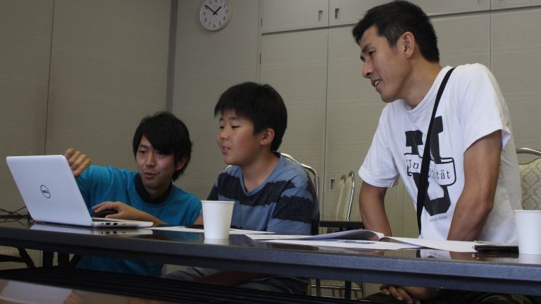 男性メンターが親子に指導している姿